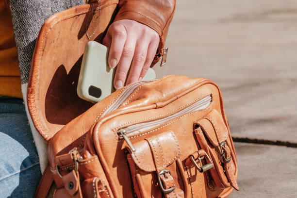istock Unrecognizable woman putting smartphone in handbag 1391172721