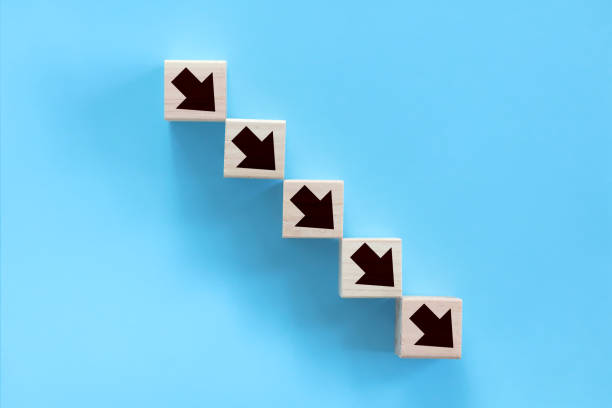 There is a stack of blocks with arrows drawn on them. The building blocks decrease from left to right as if they were going down a staircase. moving down stock pictures, royalty-free photos & images