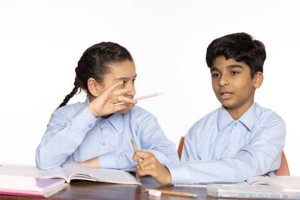 young girl and boy from primary school studying discussion in the classroom isolated on the white background stock photo
