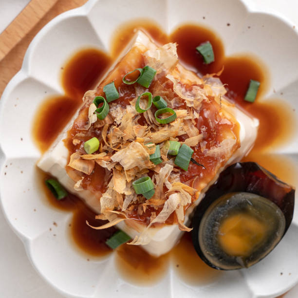 Delicious Chilled tofu and century egg with soy sauce and bonito flakes.