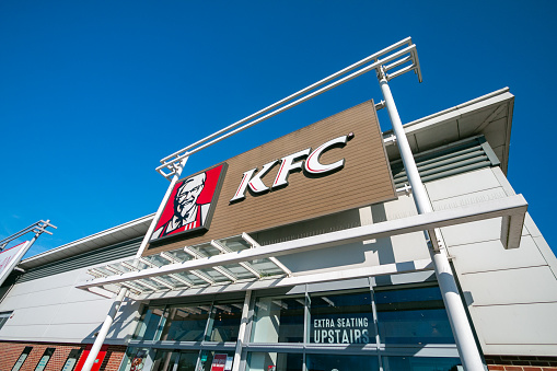 Kentucky Fried Chicken is an international fast food chain with the logo of Colonel Sanders appearing on the outside.