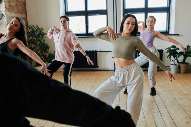 ragazze adolescenti e ragazzi che ripetono l'esercizio di danza dopo l'istruttore o il leader - vogue dancing foto e immagini stock