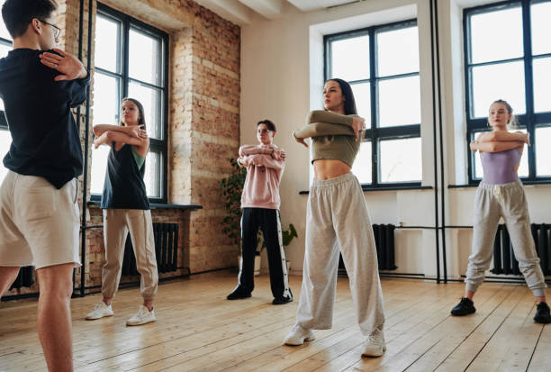 Contemporary teens standing in front of vogue dancing instructor during training
