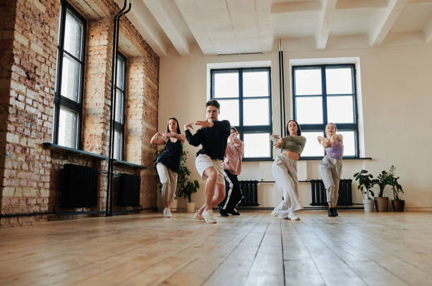 group of energetic teenagers in activewear repeating vogue dance exercise - common women teenage girls exercising imagens e fotografias de stock