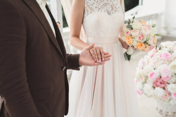 istock Bride and groom hold hands during the wedding ceremony. 1391185907