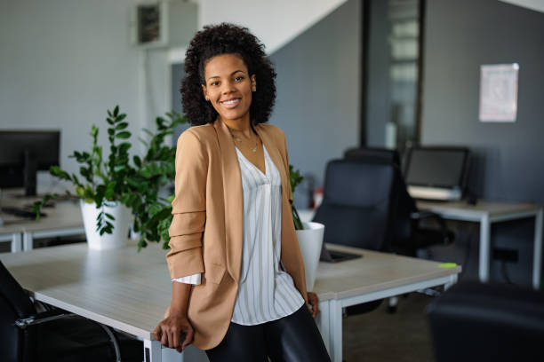 istock African woman, leaned on the table at the office, posing for the camera. 1391186125