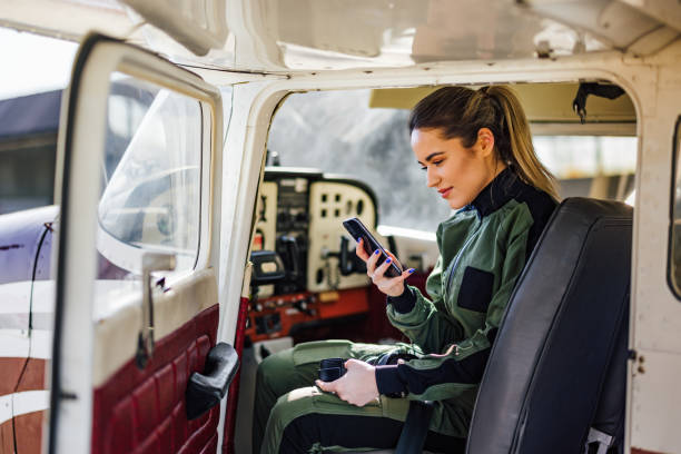istock Thougtful caucasian female aviator, reading messages on phone, s 1391186465