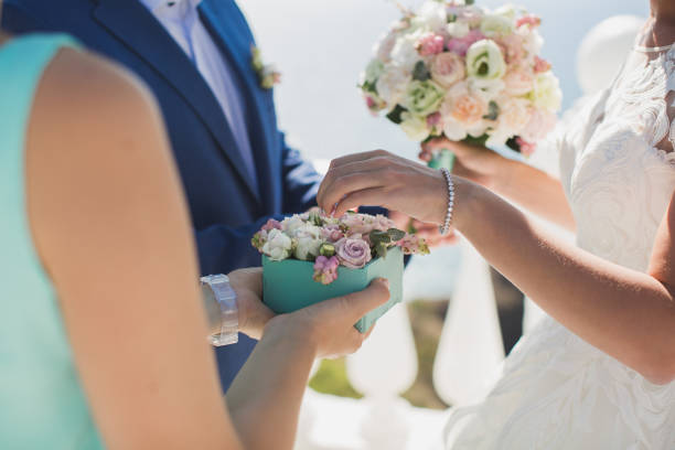 The bride puts on the hand of the groom on the background of the ocean and blue sky The bride puts on the hand of the groom on the background of the ocean and blue sky. hands of bride and bridegroom in wedding marriage ceremony stock pictures, royalty-free photos & images