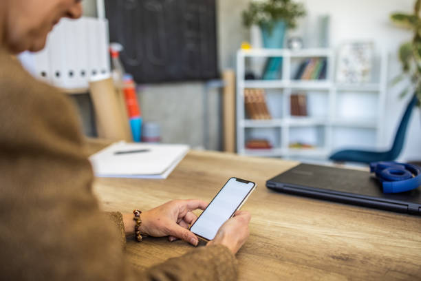 istock Unrecognizable female teacher using mobile phone for digital banking 1391188732