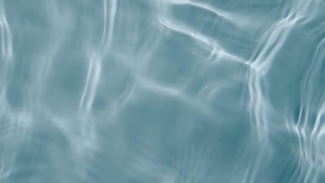 the surface of clear water with ripple waves from different directions in turquoise with feeling relaxation