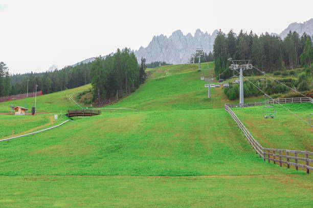 Ski resort in the summer . Green meadow and ski resort in Italian Alps