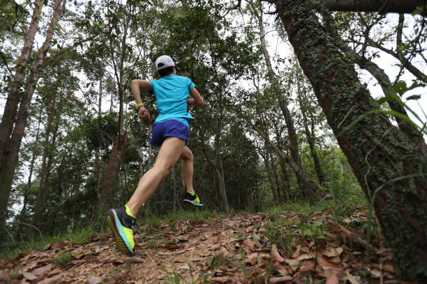 istock Woman runner running on forest trail 1391188861