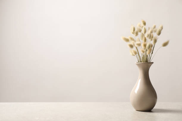 istock Dried flowers in vase on table against light background. Space for text 1391190030