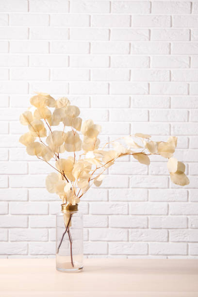 istock Dried eucalyptus branches in vase on table against white brick wall 1391190547