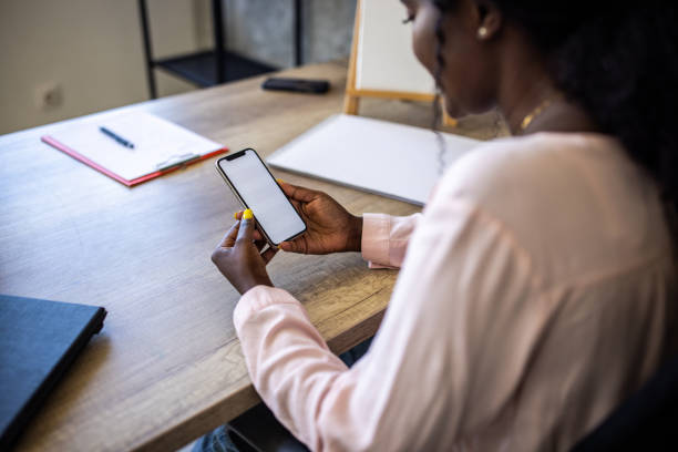 istock Female teacher Black ethnicity using mobile phone for digital banking 1391195367
