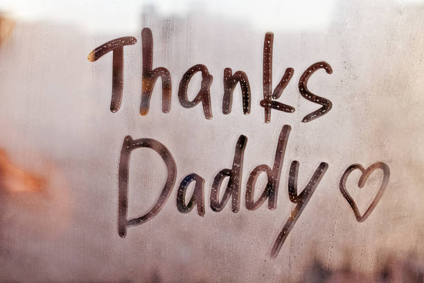 istock Handwritten text Thanks Daddy written finger with heart shape on orange sunset wet window 1391196320