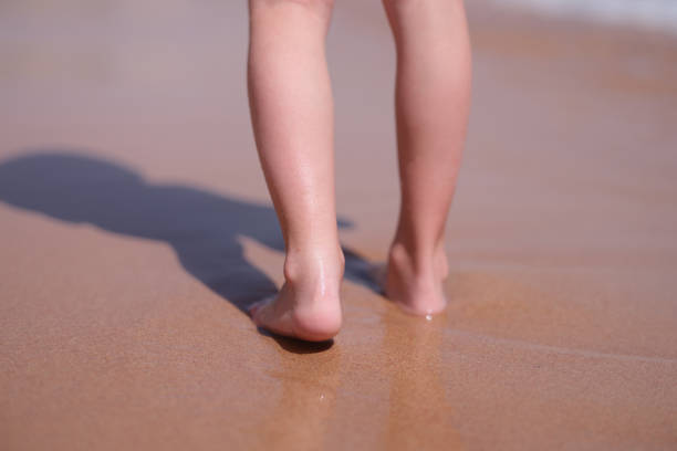 Little feet on the beach of small stones near the sea