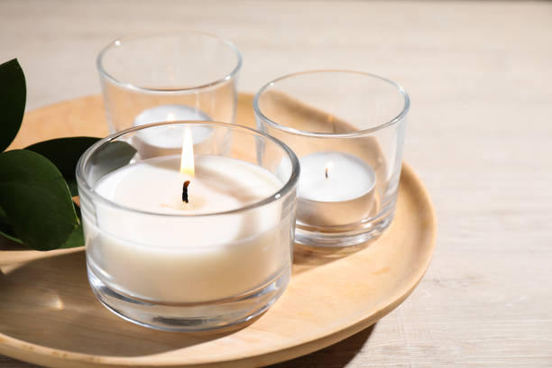 istock Plate with burning small candles on white wooden table, closeup 1391197654