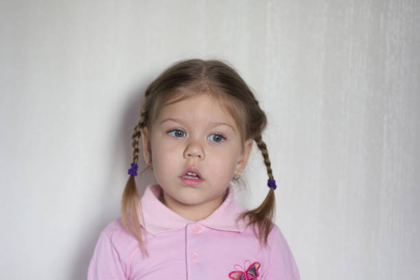 Portrait of caucasian of three age calm child without emotions looking aside on the white background