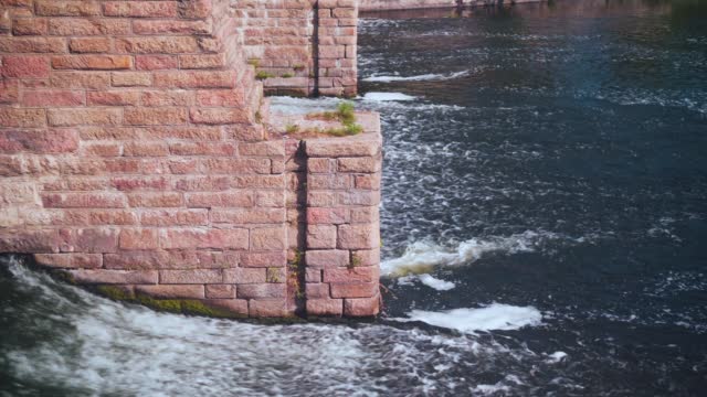 Hydroelectric dam with flowing water through gate. Clear stream calmly running by stones and good sluice made of wood. Nothing but a hydroelectric