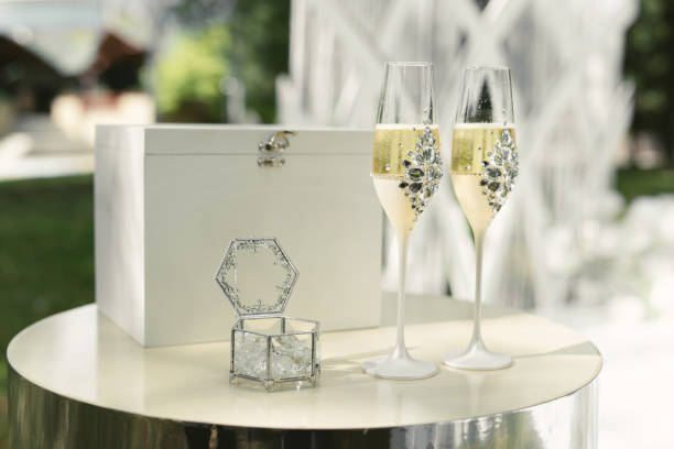 a box with wedding rings and gold sequins, champagne glasses, flowers - champagne champagne flute wedding glass imagens e fotografias de stock
