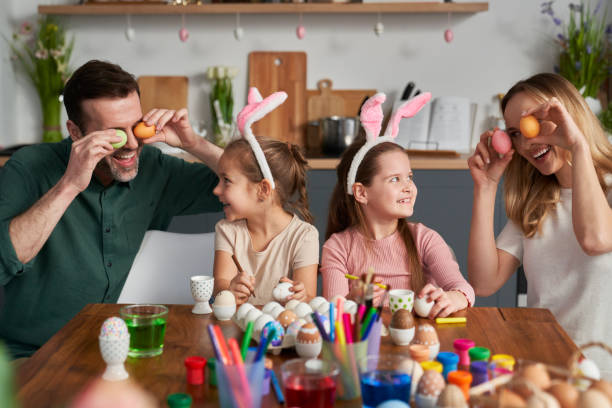 istock Happy Family Playing With Easter Eggs At Home 1391202342