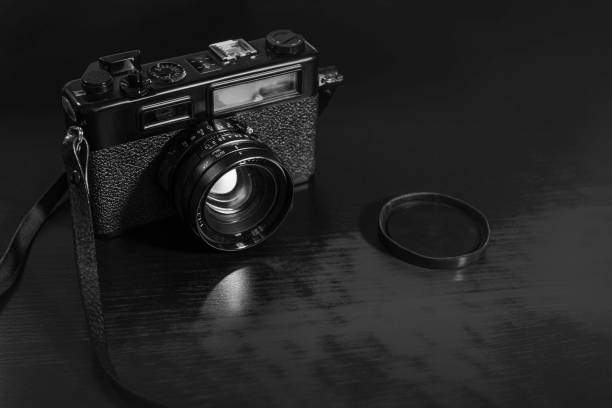 istock Retro camera on wood table background, vintage - black and white 1391202648