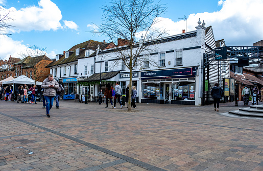 Epsom Surrey London, April 09 2022, Man Walking  Through Market Square Using Mobile Phone With People And Families In Background