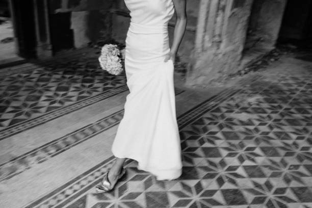 istock Elegant bride dressed in a white dress holding a wedding bouquet. 1391211452