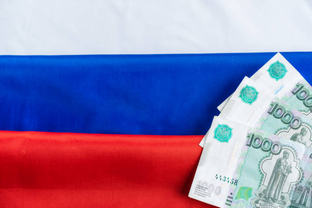 istock Russian ruble banknotes on Russian flag 1391211835