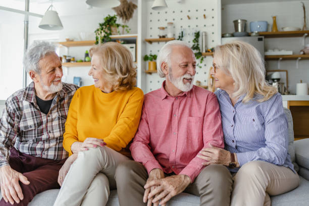 istock Four smiling senior friends at home 1391216854
