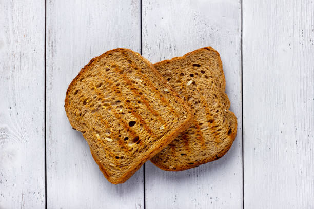 istock Toast whole wheat bread slices on wooden white background. 1391218559
