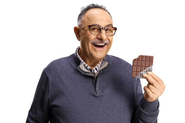 istock Mature man holding a chocolate bar and smiling 1391218573