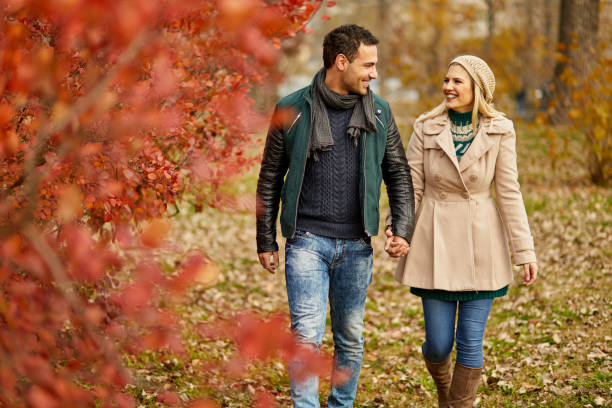 istock Young couple taking a walk in autumn park holding hands 1391218648