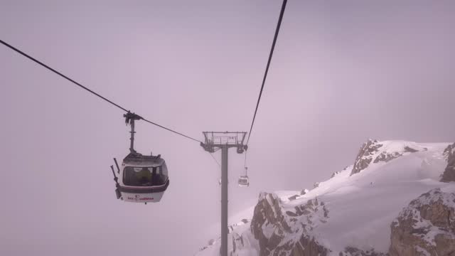 Ski lift under fog in snowcapped mountain