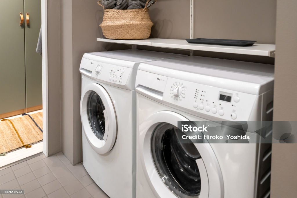 White laundry machine installed in the bathroom Washing Machine Stock Photo
