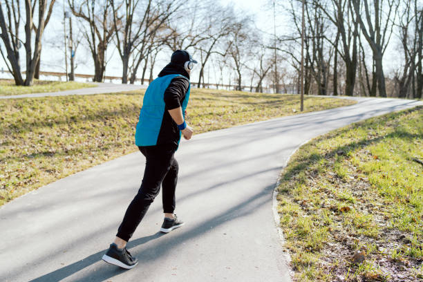 istock Athlete running, man sprinting during spring training outside in park in sunny weather. Close-up showing speed and movement. Jogging clothing, warm vest 1391219007
