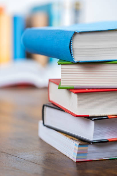 istock Pile of books on desk with blurred library background 1391221706