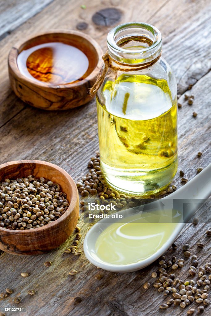 Hemp seed, oil and spoon on wooden table Cooking Oil Stock Photo
