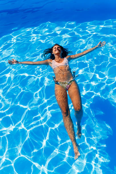 istock Woman floating on water while on summer vacation 1391222047