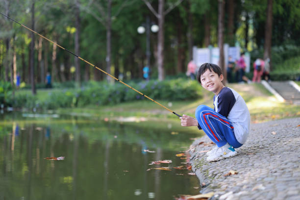 Little boy scout with backpack, binoculars and butterfly net during hiking in forest. Concepts of adventure, journey, scouting and hiking tourism for kids