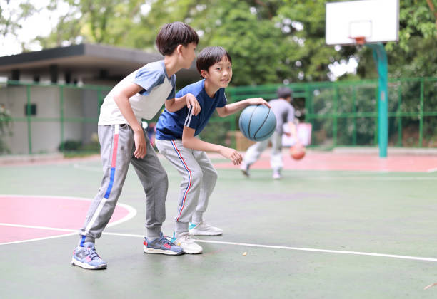 istock Two boys playing basketball outside 1391223012