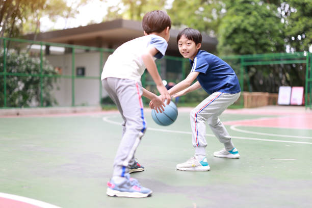 zwei jungen basketball spielen im freien - basketball teenager nature outdoors stock-fotos und bilder