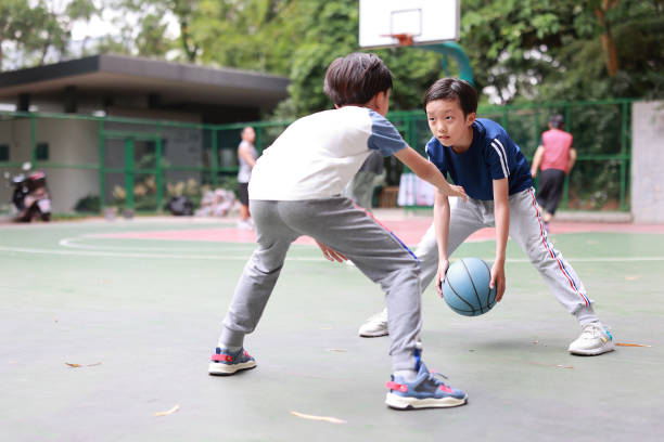 zwei jungen basketball spielen im freien - basketball teenager nature outdoors stock-fotos und bilder