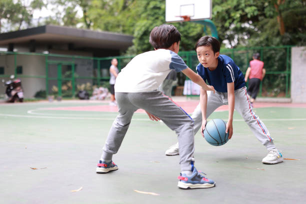 屋外で遊ぶ 2 つの男の子バスケット�ボール - basketball teenager nature outdoors ストックフォトと画像