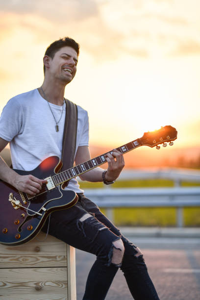 istock Guitarist Using Sunset On Highway As Inspiration While Composing Song 1391224356