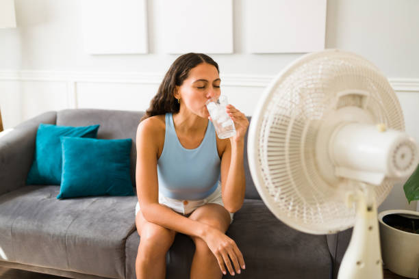 žena si vychutnává studený nápoj před ventilátorem - vějíř - stock snímky, obrázky a fotky