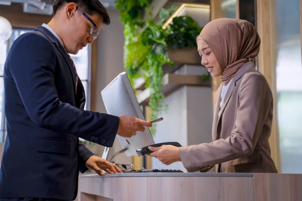 Customer is paying via electric payment at cashier counter. Customer is paying via electric payment at cashier counter. Contactless payment. new normal  and technology concept. hotel reception hotel service technology stock pictures, royalty-free photos & images