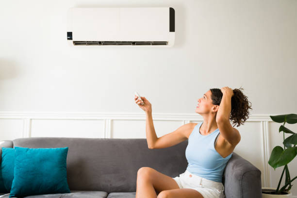 Suffering because of a broken air conditioner Hot young woman feeling sweaty during a heat wave because her air conditioning is not working broken stock pictures, royalty-free photos & images