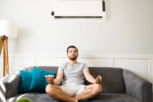 istock Handsome man meditating with the ac on 1391233373